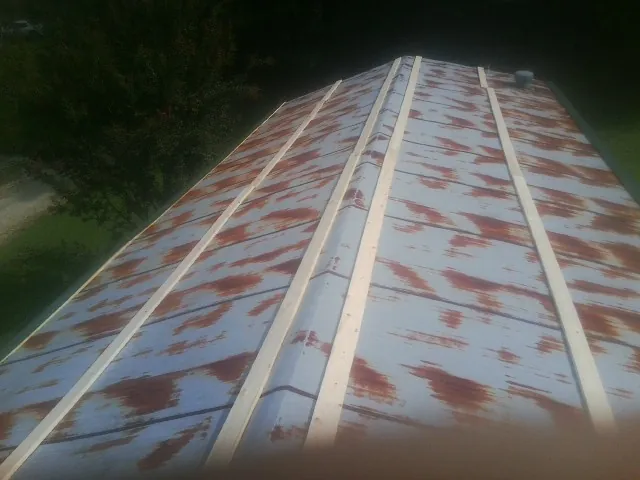Rusted metal roof panels with new wood purlins before replacement — Storm Damage Roof Repair in Dracut by Roofing Brothers